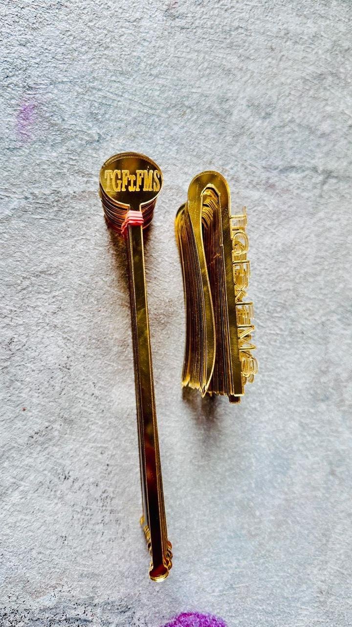Gold branded drink stirrers with text